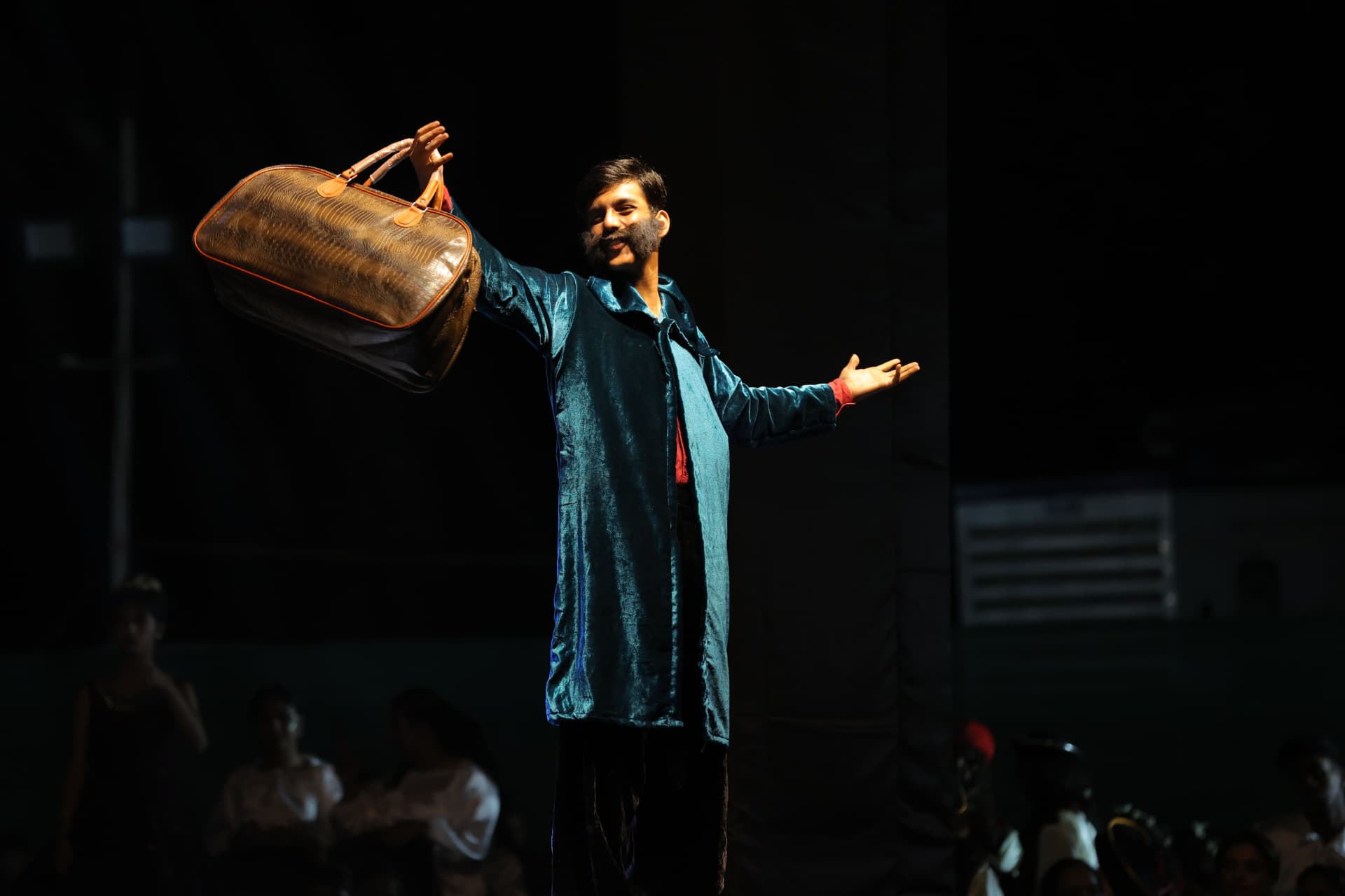 Actor performing a spotlit solo moment in a school stage production
