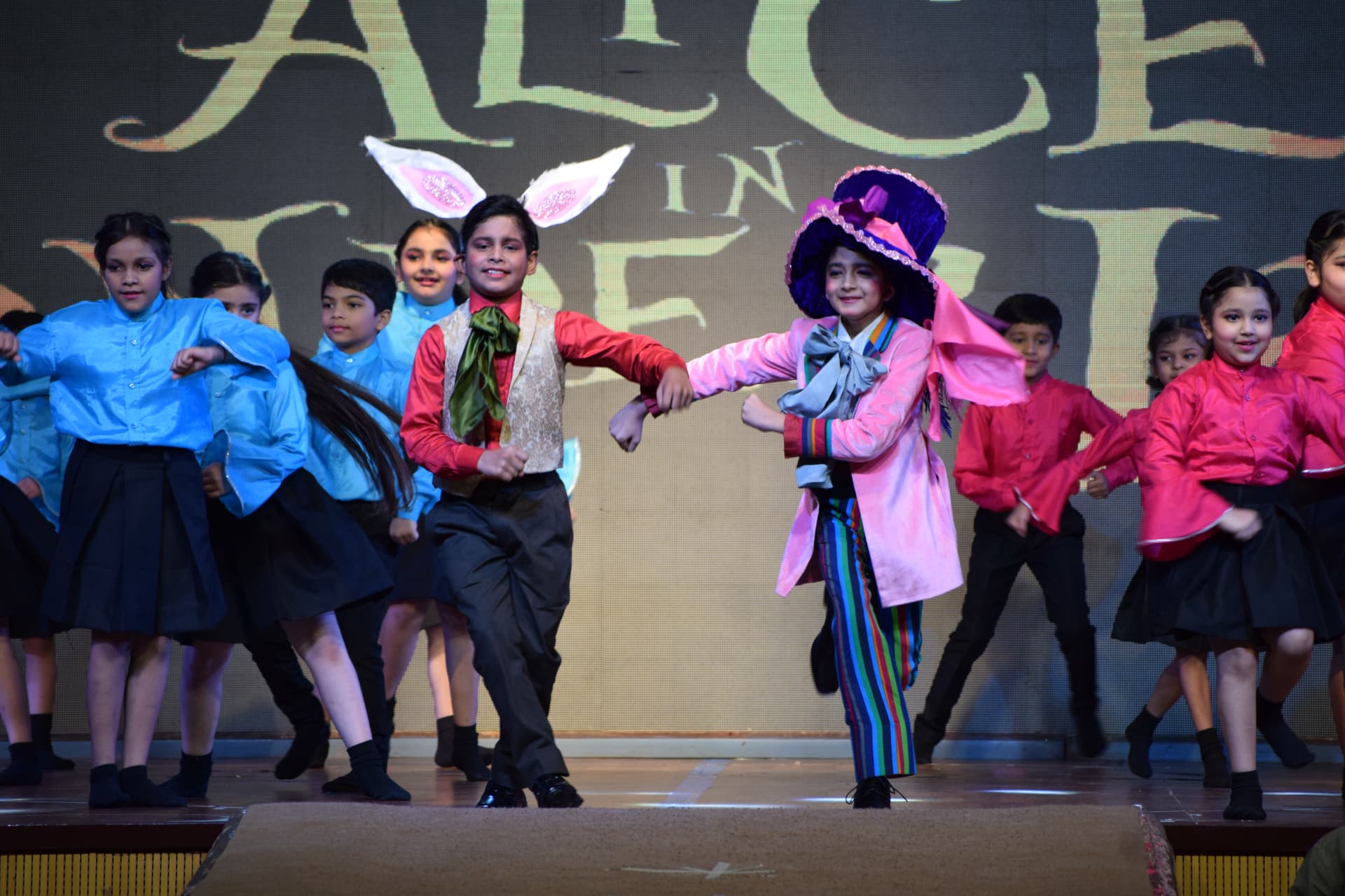 Young students performing an Alice in Wonderland annual day musical