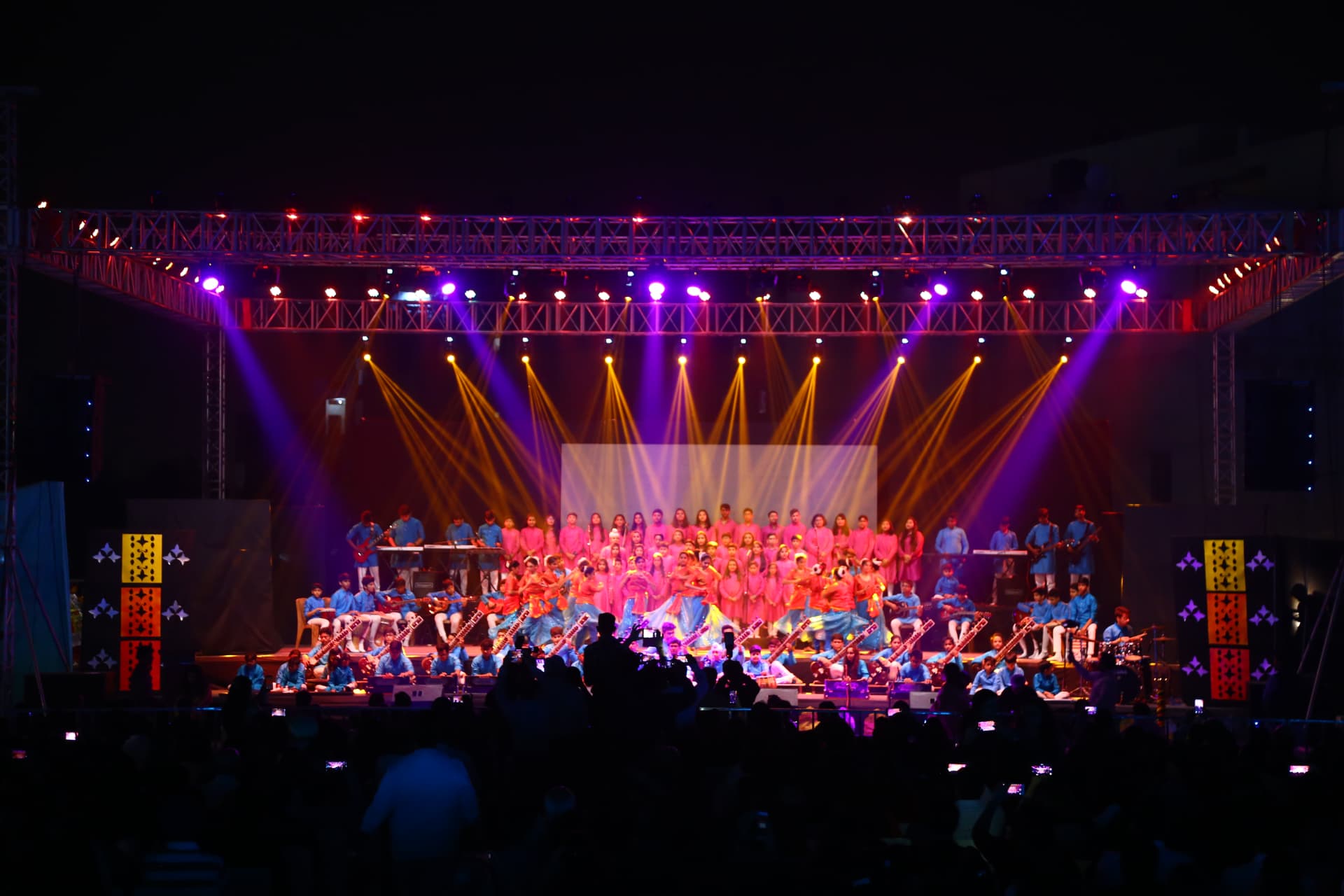 Grand open-air school annual function with full orchestra, choir and stage lighting rig